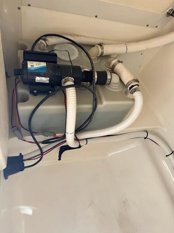 Slide: The Image of Boat plumbing system in a 2009 Edgewater 245 CX, featuring hoses and pump components. - 22