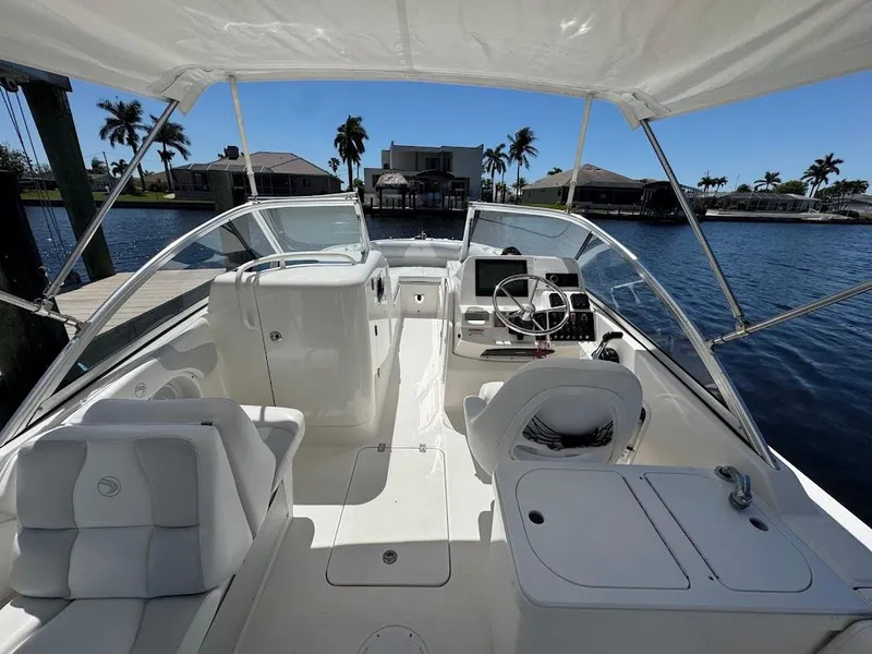 Slide: The Image of 2009 Edgewater 245 CX boat interior with seating, steering console, and waterfront view. - 23