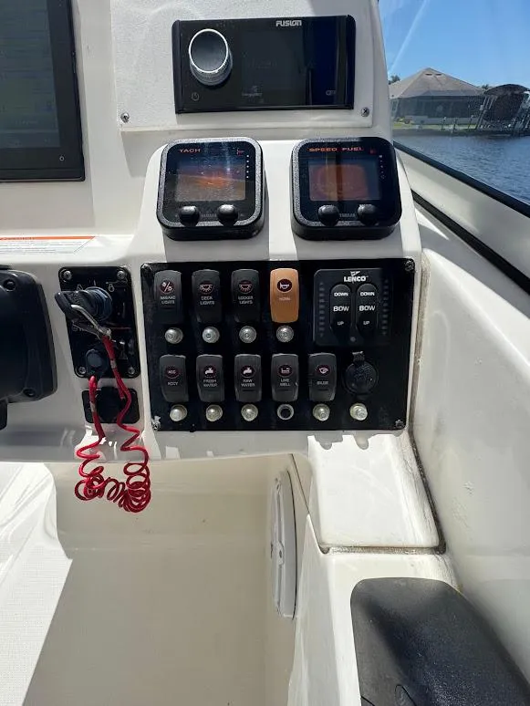 Slide: The Image of Control panel of a 2009 Edgewater 245 CX boat with various switches and gauges. - 25