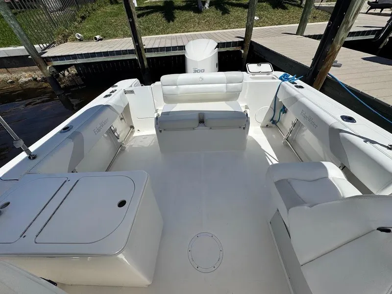 Slide: The Image of 2009 Edgewater 245 CX boat interior with white seating and deck, docked by wooden pier. - 27