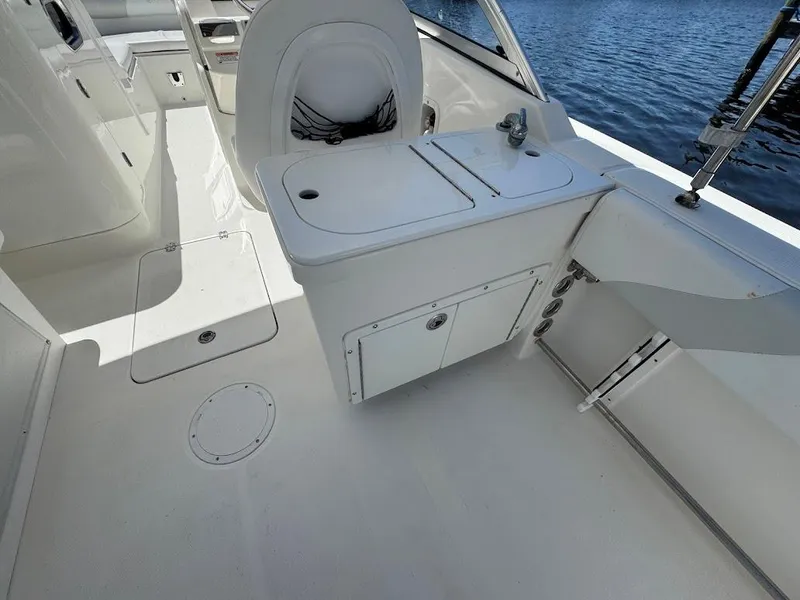 Slide: The Image of Edgewater 245 CX 2009 boat interior with seating and storage, near water. - 29