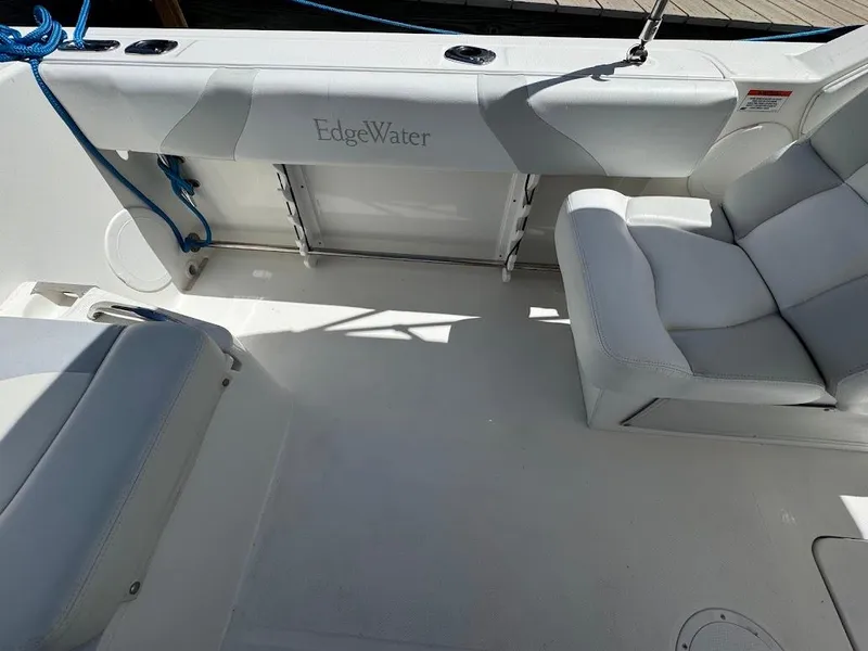 Slide: The Image of Interior of a 2009 Edgewater 245 CX boat with white seating and blue rope. - 31