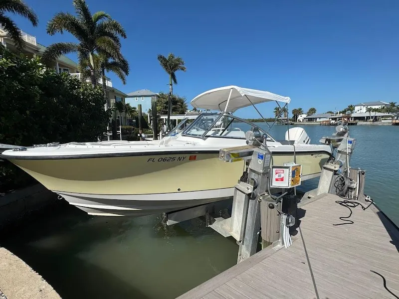 Slide: The Image of 2009 Edgewater 245 CX boat docked by waterfront with palm trees and clear sky. - 37