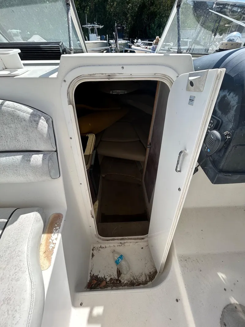 Slide: The Image of 2002 Wellcraft 2400 Martinique cabin entrance with open door, showing interior seating. - 7