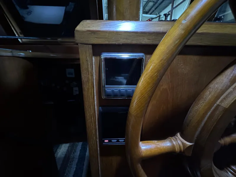 Slide: The Image of 1983 Marine Trader 44 Sundeck helm with wooden steering wheel and control panel. - 11