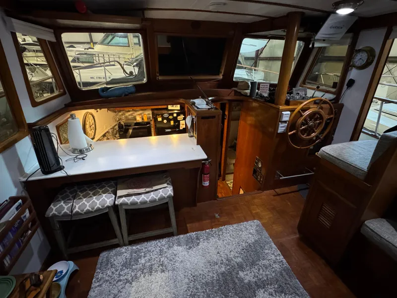Slide: The Image of 1983 Marine Trader 44 Sundeck interior with helm, seating, and kitchen area. - 15