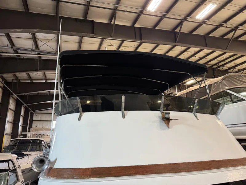Slide: The Image of 1983 Marine Trader 44 Sundeck yacht in indoor storage, featuring a black canopy. - 17