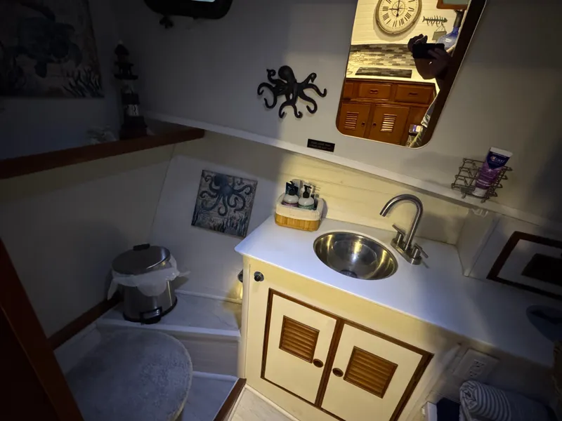 Slide: The Image of 1983 Marine Trader 44 Sundeck bathroom with sink, mirror, and nautical decor. - 19