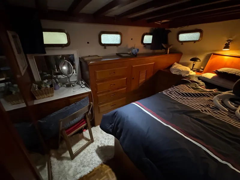 Slide: The Image of Cozy bedroom in 1983 Marine Trader 44 Sundeck yacht with wooden furnishings and nautical decor. - 24