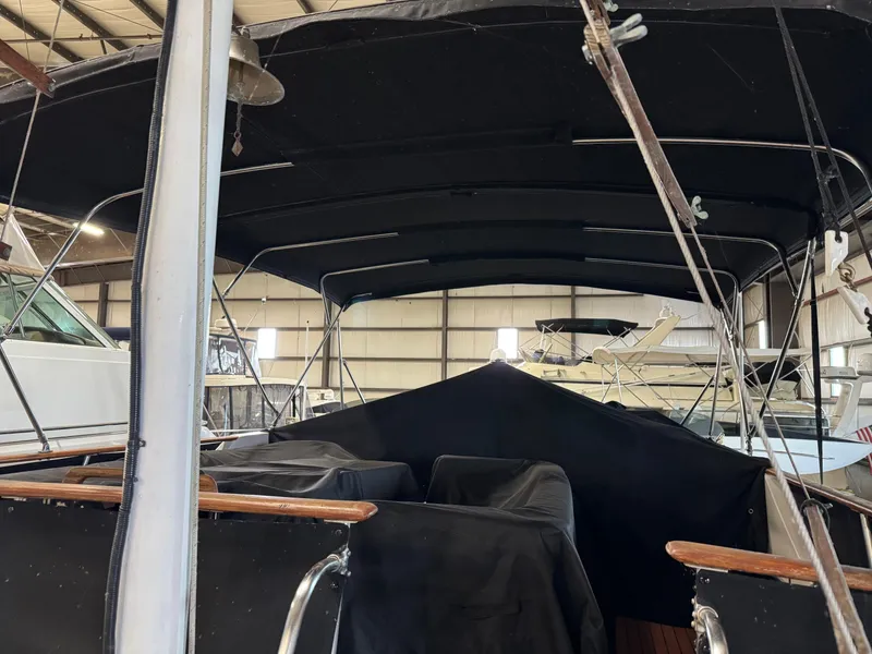 Slide: The Image of 1983 Marine Trader 44 Sundeck yacht with black canopy in a storage facility. - 25