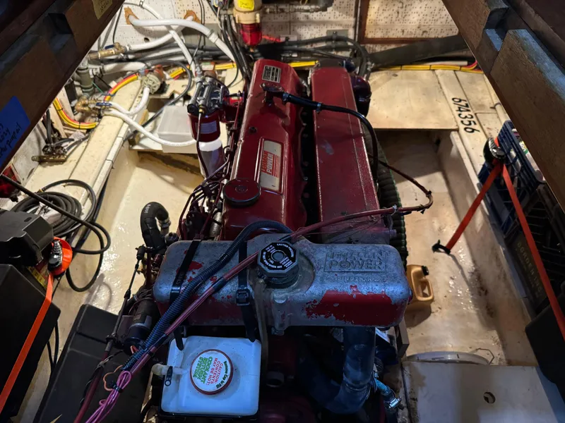 Slide: The Image of Engine room of 1983 Marine Trader 44 Sundeck with visible red engine components. - 26