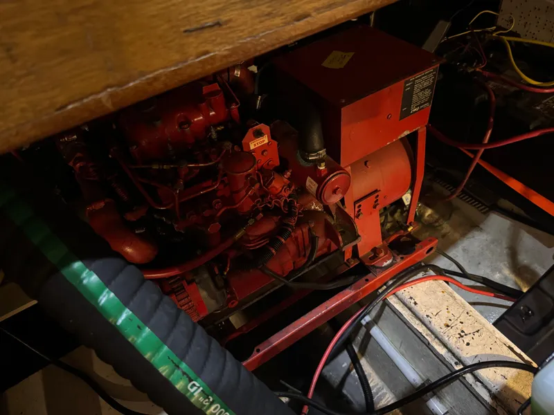 Slide: The Image of Engine compartment of a 1983 Marine Trader 44 Sundeck, featuring red machinery and wiring. - 27