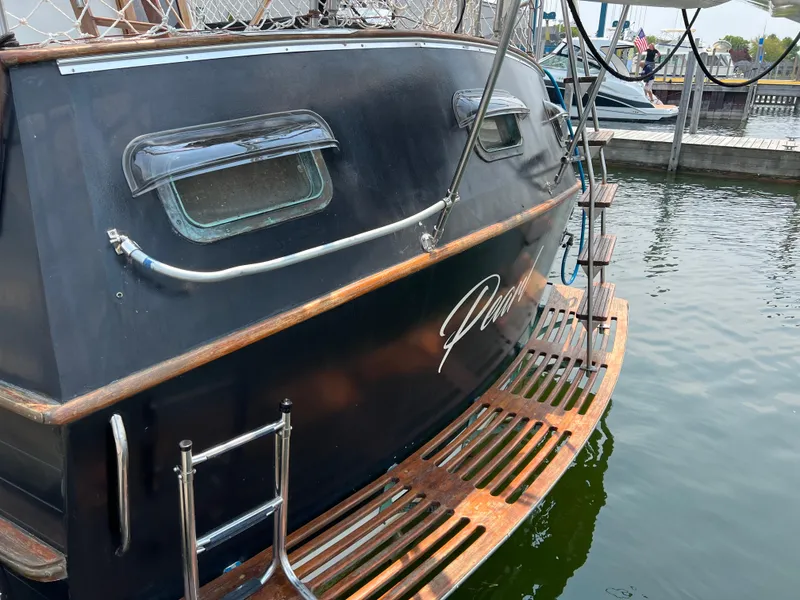 Slide: The Image of 1983 Marine Trader 44 Sundeck boat stern with wooden swim platform at dock. - 3