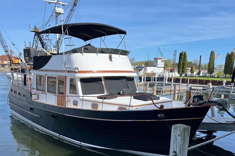 Slide: The Image of 1983 Marine Trader 44 Sundeck yacht docked at a marina under clear blue skies. - 30