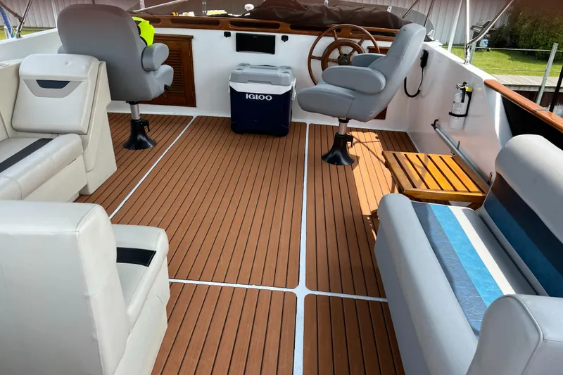 Slide: The Image of 1983 Marine Trader 44 Sundeck interior with seating, wooden flooring, and steering wheel. - 4