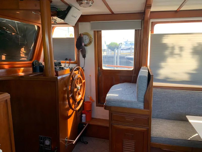 Slide: The Image of Interior of 1983 Marine Trader 44 Sundeck with wooden helm and seating area. - 8