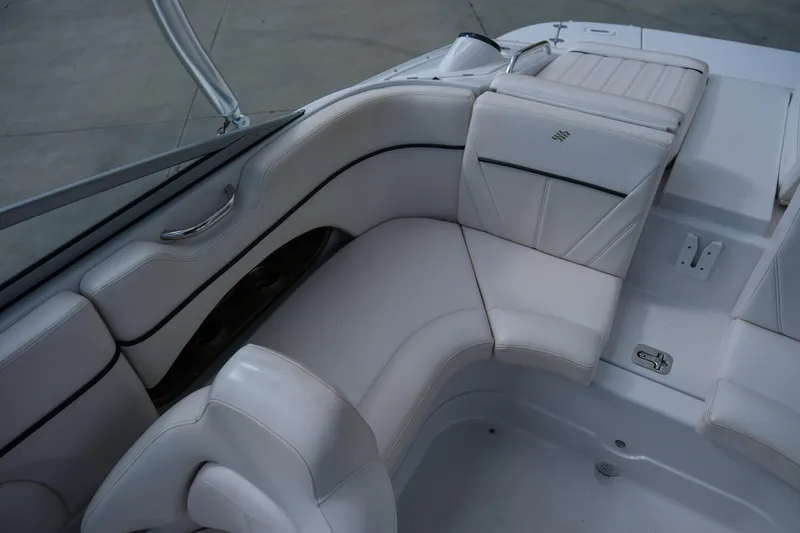 Slide: The Image of Interior seating of a 2010 Four Winns 220H boat, featuring white upholstery. - 11
