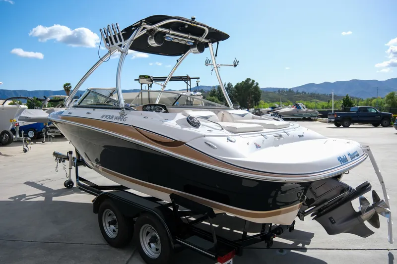 Slide: The Image of 2010 Four Winns 220H boat on trailer, sleek design, sunny outdoor setting. - 4