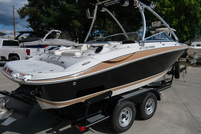 Slide: The Image of 2010 Four Winns 220H boat on trailer, black and white design, parked outdoors. - 6