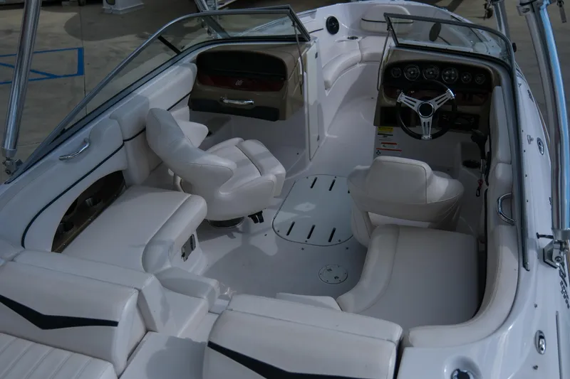 Slide: The Image of 2010 Four Winns 220H boat interior with white seating and steering wheel. - 9