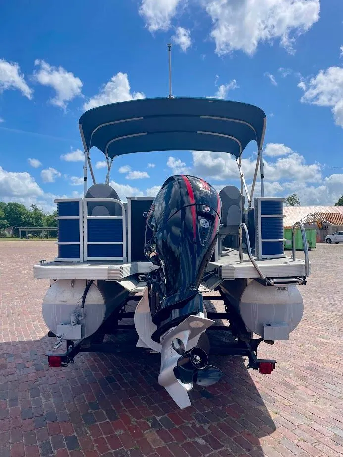 Slide: The Image of 2022 Bennington SX 23 Fishing boat with outboard motor, parked on brick surface under blue sky. - 5