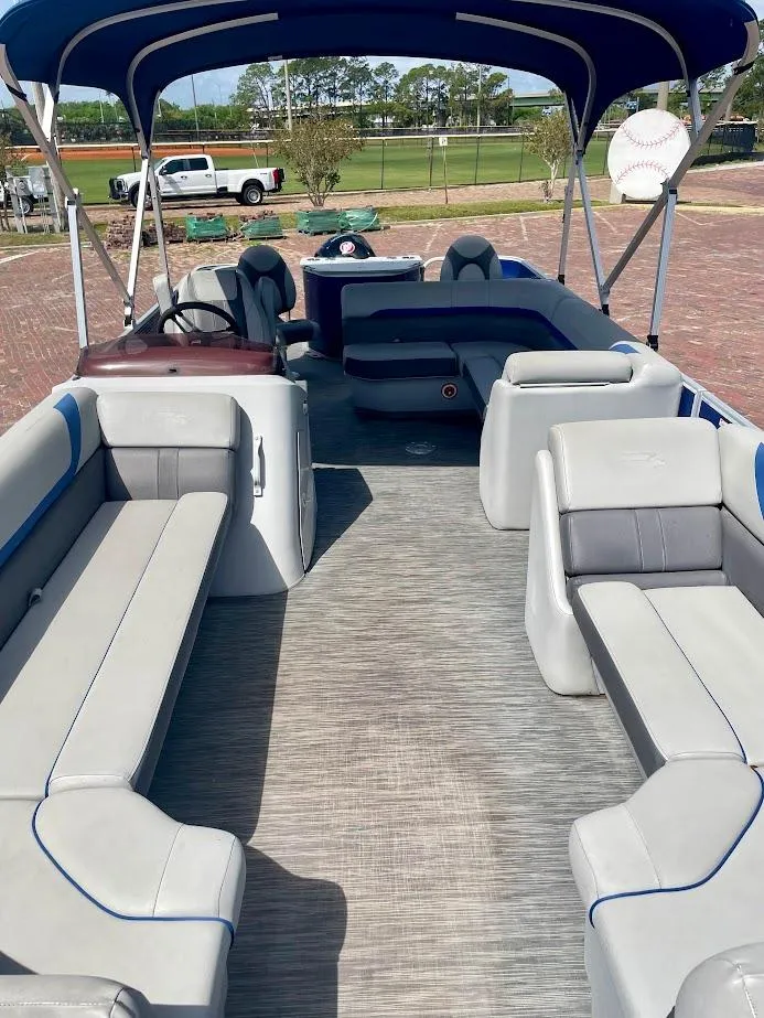 Slide: The Image of 2022 Bennington SX 23 Fishing boat with spacious seating and canopy, parked outdoors. - 8