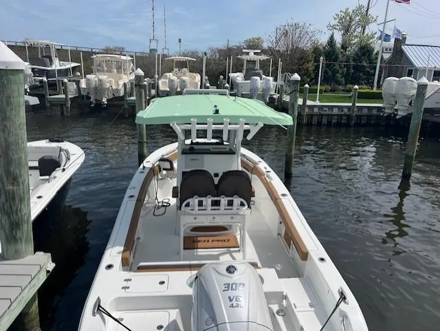 Slide: The Image of 2025 Sea Pro 242 Center Console boat docked, featuring a 300 V6 engine and green canopy. - 2