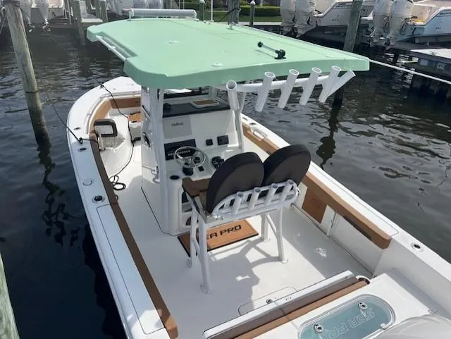Slide: The Image of 2025 Sea Pro 242 Center Console boat docked, featuring a mint green T-top and dual seating. - 4