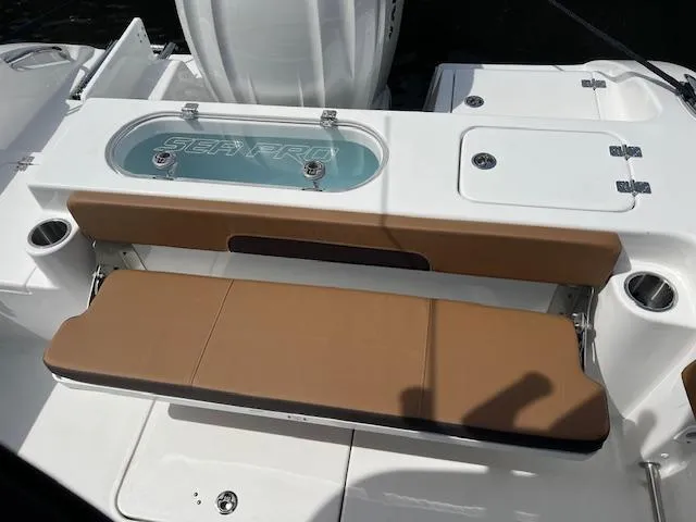Slide: The Image of 2025 Sea Pro 242 Center Console boat with tan seating and storage compartments. - 6