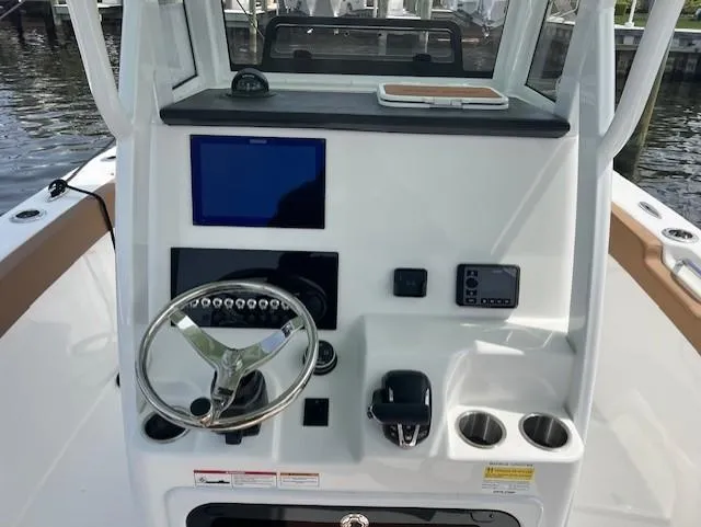 Slide: The Image of 2025 Sea Pro 242 Center Console boat dashboard with steering wheel and electronic controls. - 8