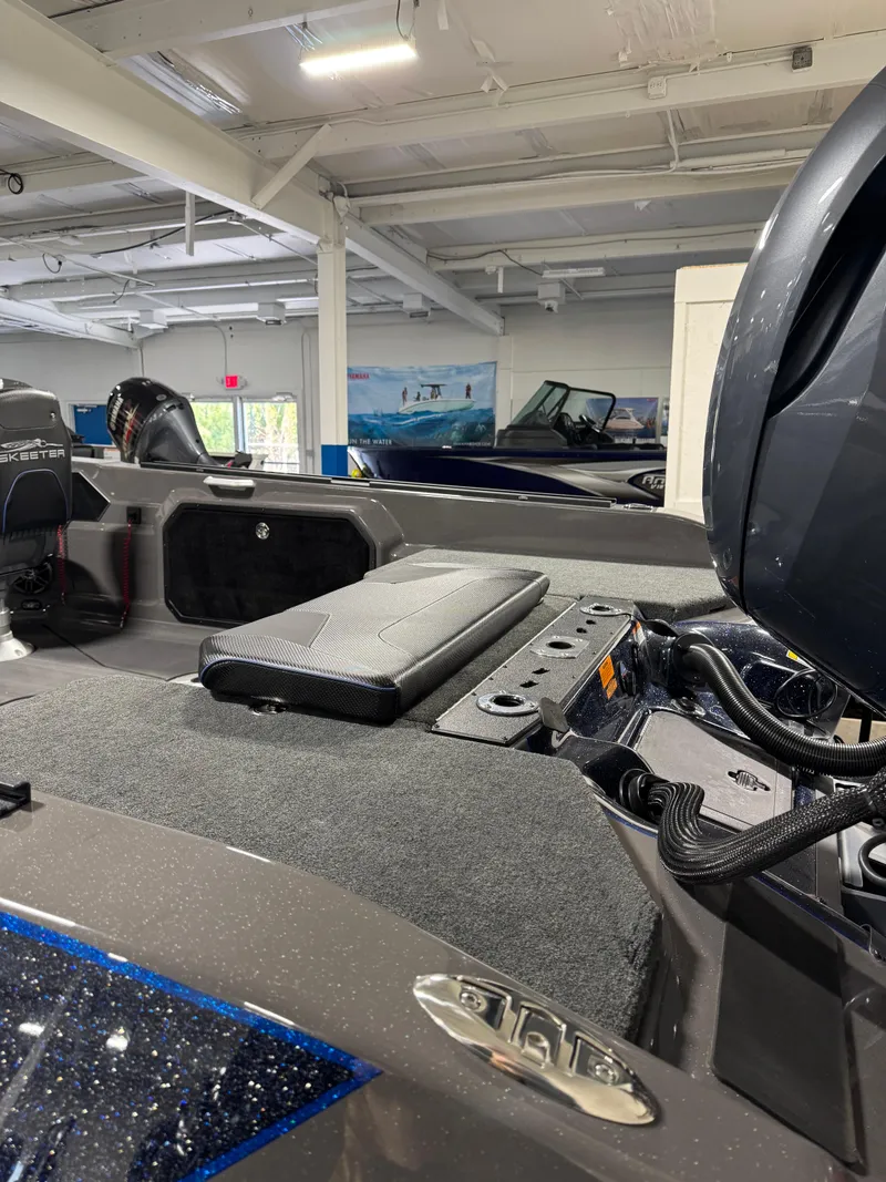 Slide: The Image of 2025 Skeeter WXR 2260 F boat interior in showroom, showcasing seating and engine area. - 6