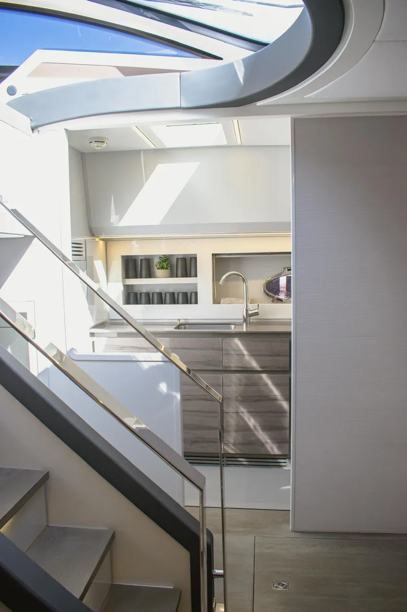 Slide: The Image of Modern kitchen interior on a 2014 Pershing 62 yacht, featuring sleek cabinetry and natural lighting. - 10