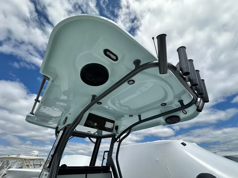 Slide: The Image of 2025 Sea Pro 292 Offshore boat canopy with rod holders against a cloudy sky. - 22