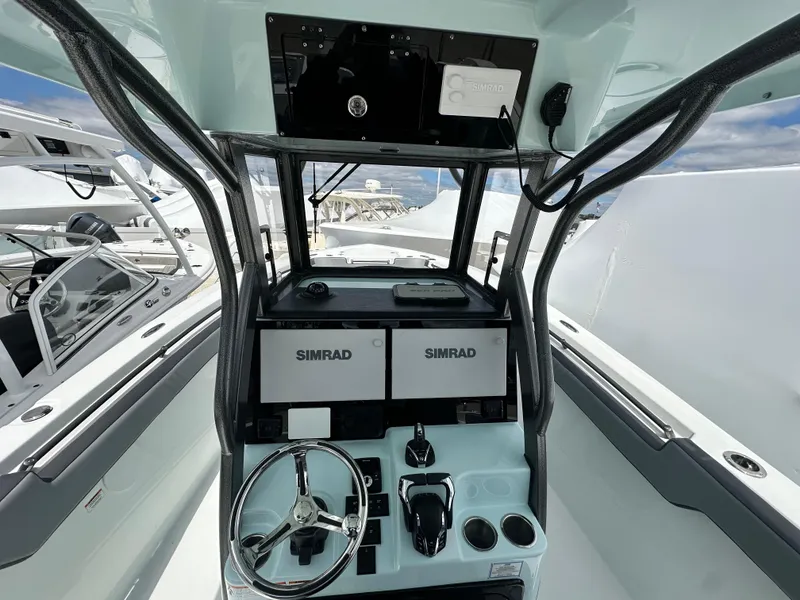 Slide: The Image of 2025 Sea Pro 292 Offshore boat dashboard with dual Simrad displays and steering wheel. - 24