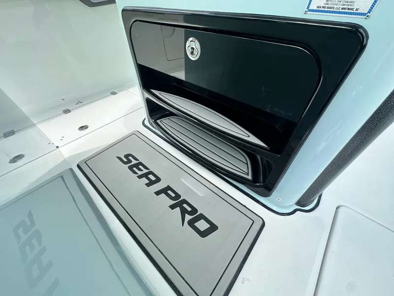 Slide: The Image of 2025 Sea Pro 292 Offshore boat interior with branded mat and storage compartment. - 30