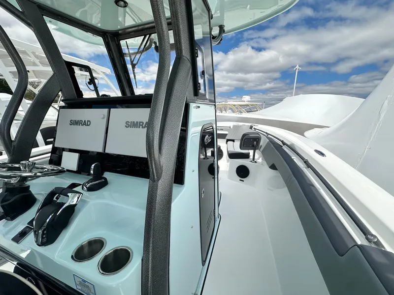 Slide: The Image of 2025 Sea Pro 292 Offshore boat cockpit with Simrad electronics, under a clear blue sky. - 31
