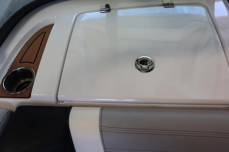 Slide: The Image of 2020 Nautique Super Air Nautique 230 interior detail with cup holder and storage compartment. - 14