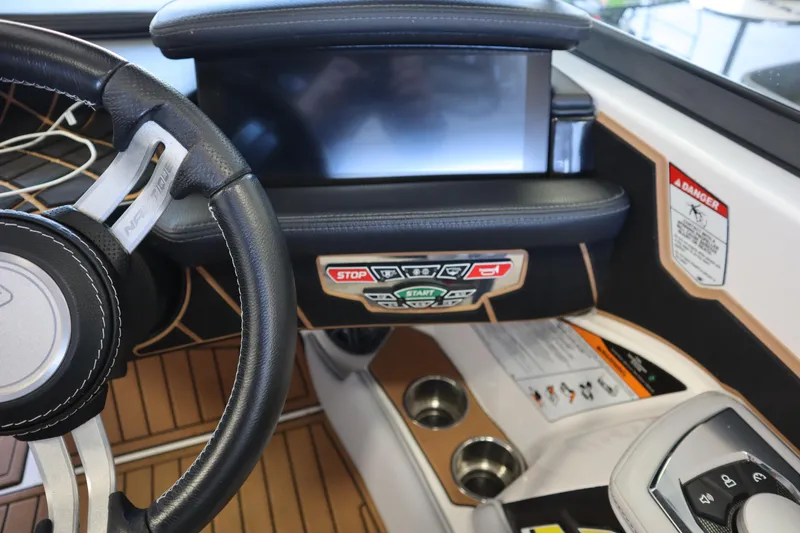 Slide: The Image of 2020 Nautique Super Air Nautique 230 dashboard with steering wheel and control panel. - 16