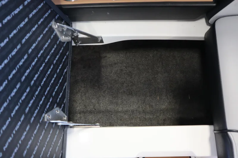 Slide: The Image of 2020 Nautique Super Air Nautique 230 interior storage compartment with carpeted flooring. - 25