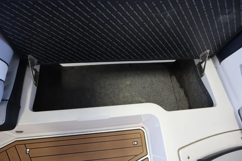 Slide: The Image of 2020 Nautique Super Air Nautique 230 storage compartment with open lid and wooden flooring. - 26