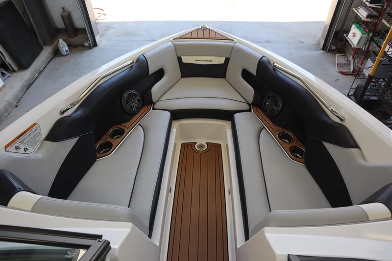Slide: The Image of 2020 Nautique Super Air Nautique 230 boat interior with cushioned seating and cup holders. - 4