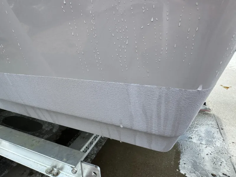 Slide: The Image of Close-up of a 2022 Key West 219 FS boat hull on a trailer, showing water droplets. - 13
