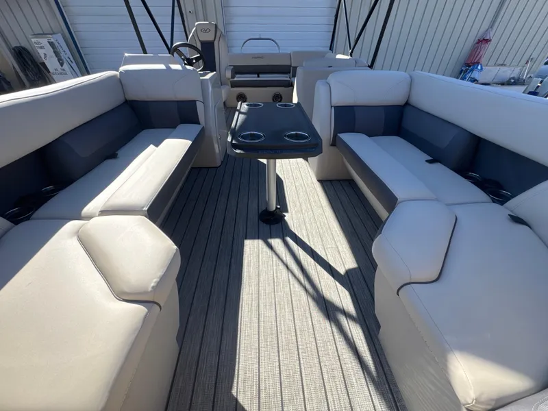 Slide: The Image of 2023 Harris HCX230 SL pontoon boat interior with spacious seating and central table. - 11