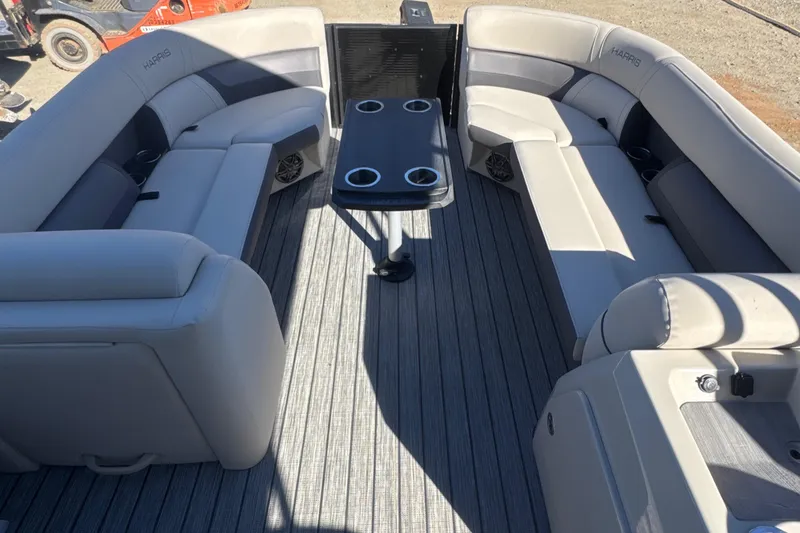 Slide: The Image of 2023 Harris HCX230 SL boat interior with gray seating and central table. - 15