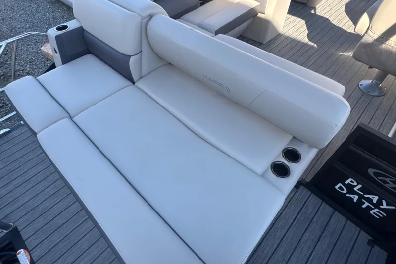 Slide: The Image of 2023 Harris HCX230 SL boat interior with plush seating and cup holders. - 23