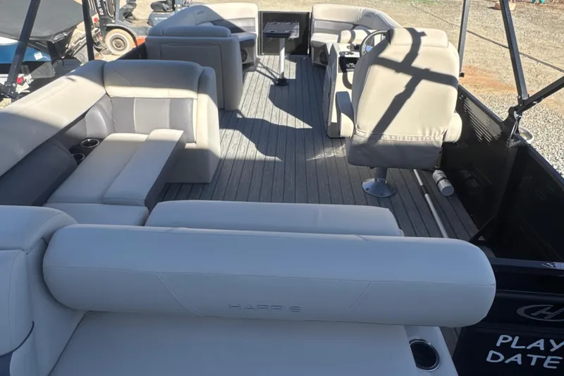 Slide: The Image of 2023 Harris HCX230 SL pontoon boat with spacious seating and modern interior design. - 24