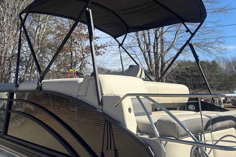 Slide: The Image of 2023 Harris HCX230 SL pontoon boat with canopy, beige seating, and sleek design. - 4