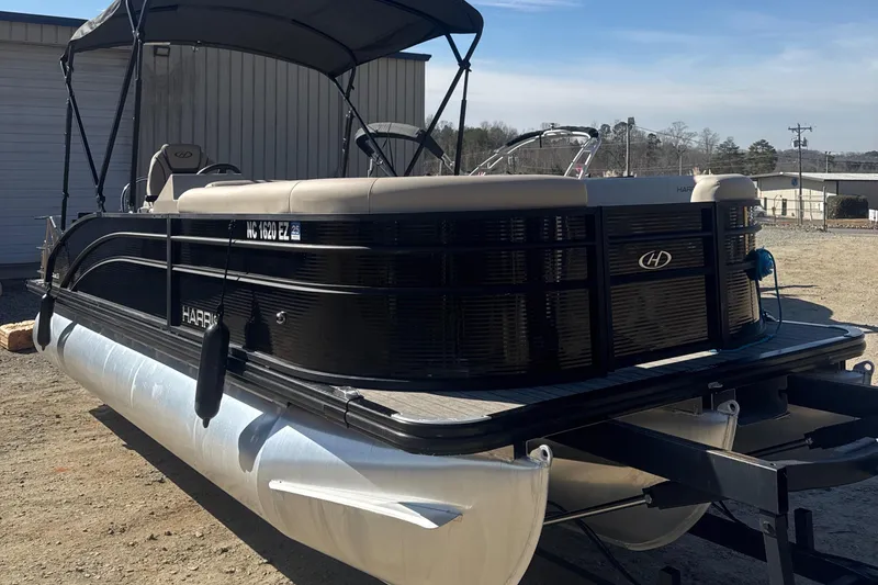 Slide: The Image of 2023 Harris HCX230 SL pontoon boat with canopy, parked outdoors on a sunny day. - 9