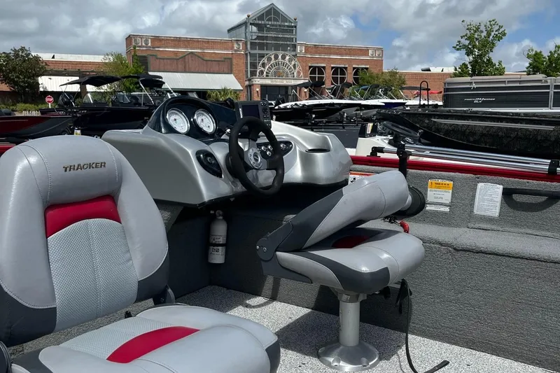 Slide: The Image of 2012 Tracker Pro Guide V-175 SC boat interior with steering wheel and seats, outdoors. - 3