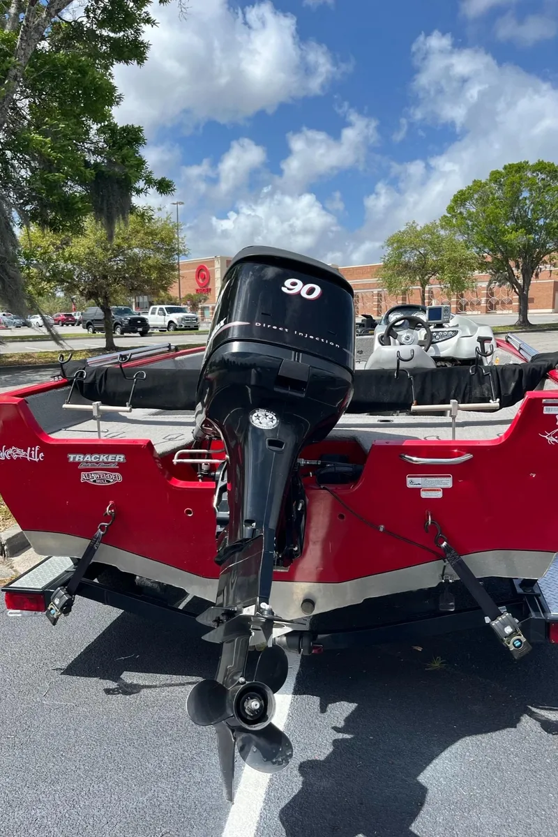 Slide: The Image of 2012 Tracker Pro Guide V-175 SC boat with 90 HP motor, parked outdoors. - 4